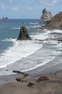 Scenic view of rocks on beach against sky