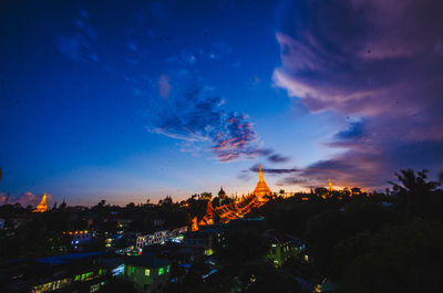 Illuminated buildings against sky at dusk