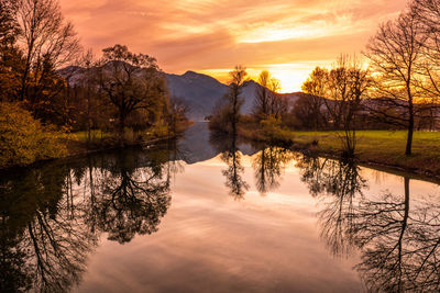 Reflection of trees in lake during sunset