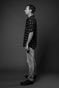 Side view of young man looking away over white background