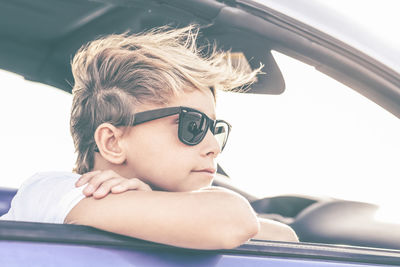 Thoughtful boy enjoying summer day sitting in the car portrait of teen looking out of the car window