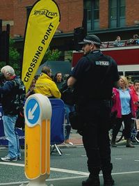 Rear view of people standing on street in city