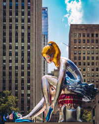 Young woman in city against sky