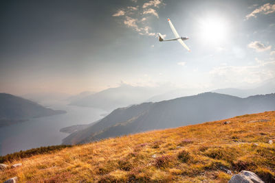 Airplane flying over mountains against sky