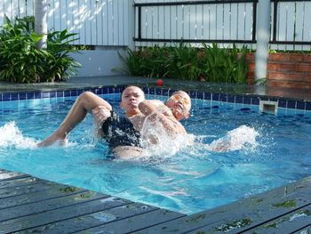 Siblings enjoying in swimming pool