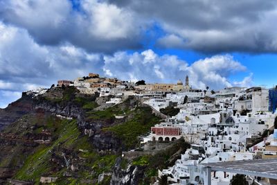 Buildings in town against cloudy sky