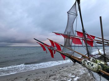 Red flag on beach against sky