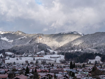 Aerial view of townscape and mountains against sky