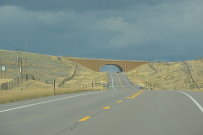 Road passing through landscape against sky