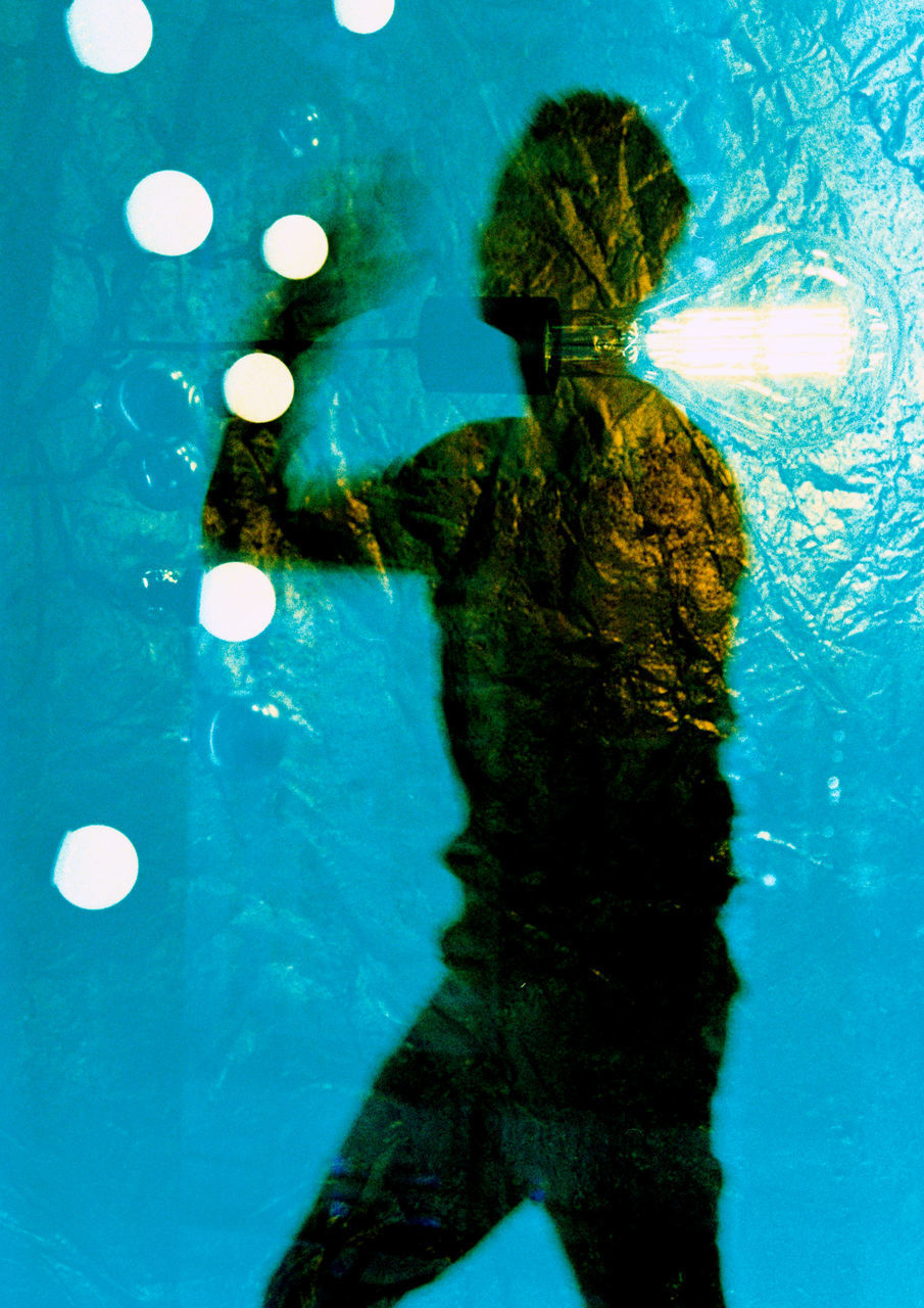 REAR VIEW OF WOMAN SWIMMING IN POOL AT SEA