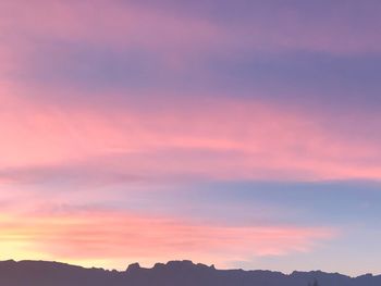 Silhouette mountain against dramatic sky during sunset