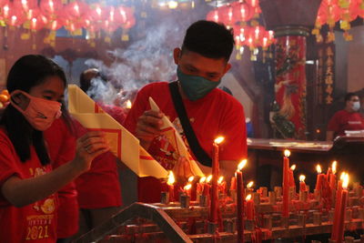 Panoramic view of man holding lit candles