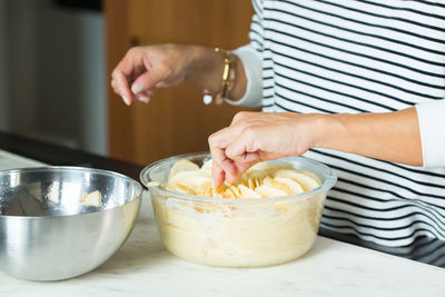 Cropped hand of woman preparing food on table