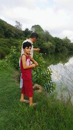 Boy standing by lake