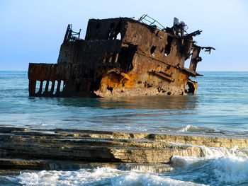 Abandoned built structure on beach against clear sky