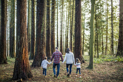 Rear view of mother and father enjoying time with their kids outdoors.