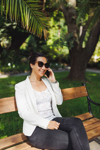 Young asian business woman in casual blazer making phone call outdoor