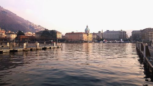 River by buildings against clear sky