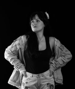 Portrait of beautiful young woman against black background