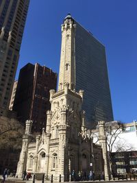 Low angle view of water tower place against clear blue sky in city