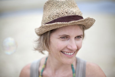 Smiling woman wearing straw hat on beach