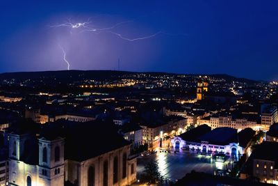 Aerial view of illuminated city against sky at night