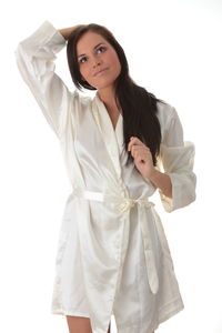 Portrait of young woman standing against white background
