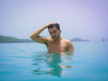 Shirtless man swimming in sea