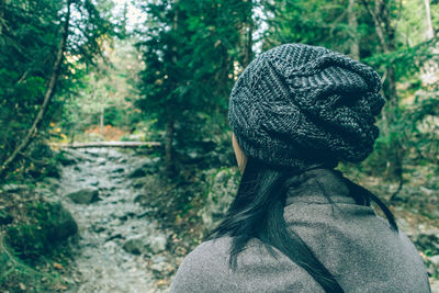 Rear view of woman looking at trees in forest