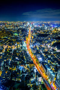 High angle view of illuminated city street against sky at night