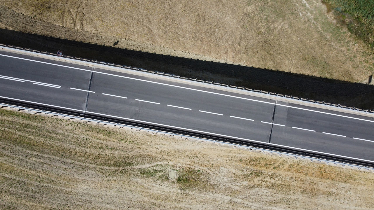 HIGH ANGLE VIEW OF RAILROAD TRACKS ON ROAD