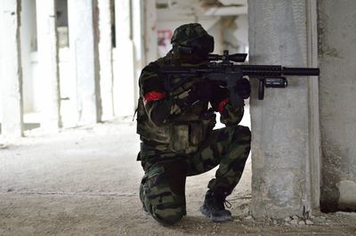 Army solider with machine gun in abandoned building