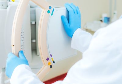 Midsection of doctor holding equipment in hospital