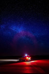 Car on illuminated road in city at night