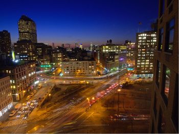 High angle view of illuminated street amidst buildings in city at night