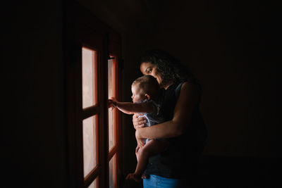 Side view of father and son standing in room