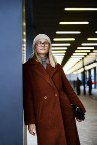 Woman in coat walks at city stret