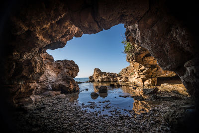 Rock formation in sea against sky