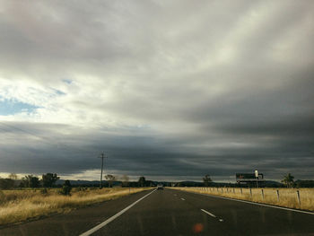 Highway against cloudy sky