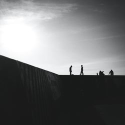 Low angle view of silhouette people against sky