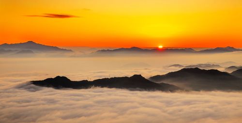 Scenic view of mountains against orange sky