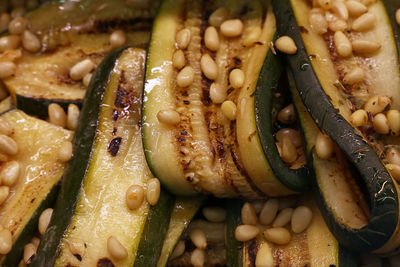Close-up of grilled zucchini slices with cedar nuts