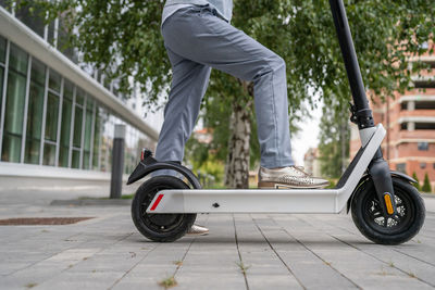 Man riding push scooter on street