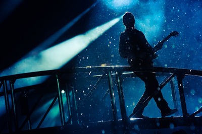 Low angle view of guitarist performing on stage during concert