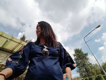 Low angle view of woman standing against sky