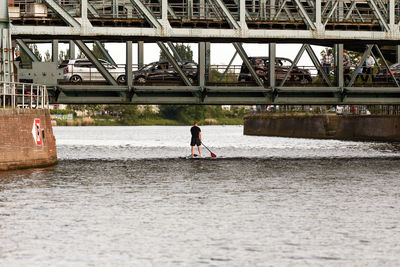 Man standing on bridge over river