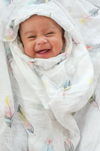 High angle view of cute baby lying on bed