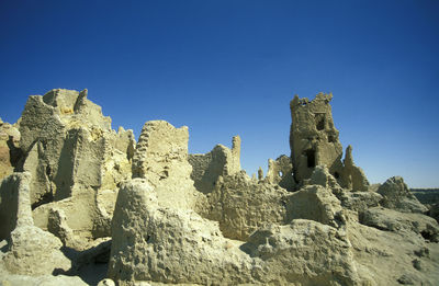 Rock formations against clear blue sky