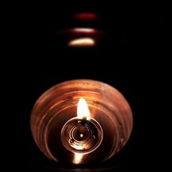 Close-up of lit candle in dark room