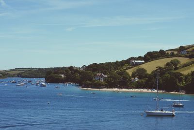 Boats sailing in sea against sky